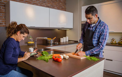 Young man preparing food in kitchen at home