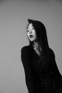 Portrait of beautiful young woman against white background