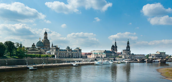 View of buildings at waterfront against cloudy sky