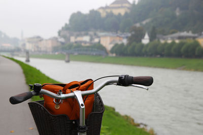 Travel to salzburg, austria. a bicycle on a view of a park, a river and mountains.