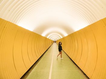 Full length of woman walking in tunnel