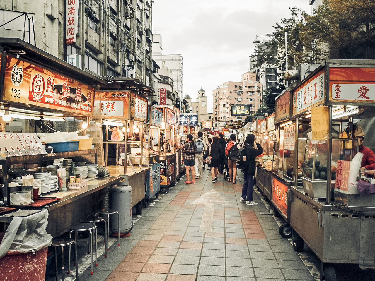 PEOPLE ON STREET AMIDST BUILDINGS IN CITY