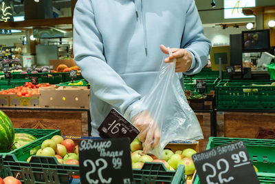 Midsection of man holding vegetables for sale