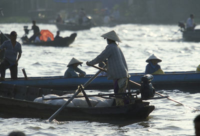 People sailing boat on river