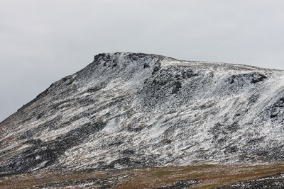 Low angle view of snowcapped mountain against sky