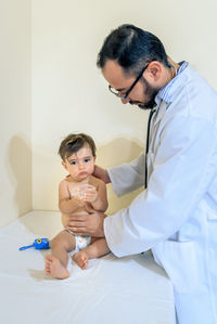 Doctor observing a one-year-old baby