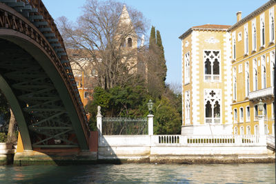 Bridge over river against buildings