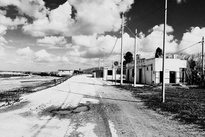 Puddle on street against cloudy sky