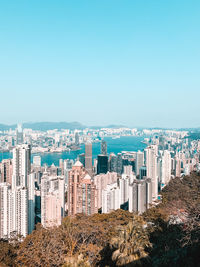 Buildings in city against clear blue sky