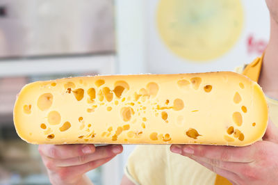 Cropped image of hands holding cheese