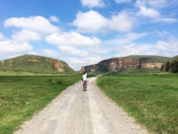 Rear view of woman on road against sky