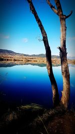 Scenic view of lake against clear blue sky