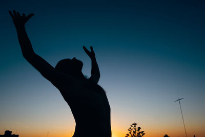 Silhouet of man stretching during sunset