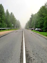 Empty road along trees