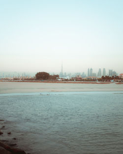 View of sea and buildings against clear sky