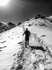 Rear view of man on snowcapped mountain against sky