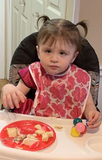 Portrait of cute girl having food on table