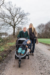 Portrait of happy family standing on dirt road