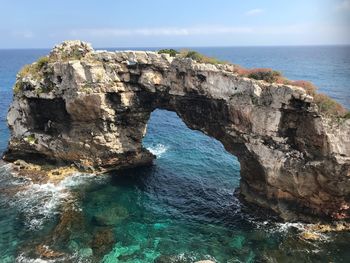 Rock formations in sea against sky