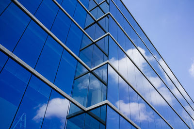 Low angle view of glass building against sky