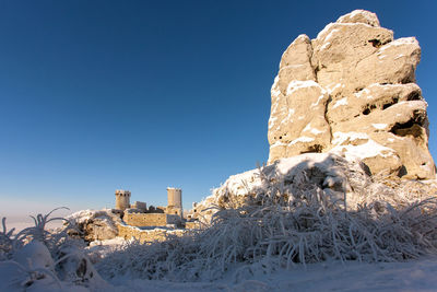 Scenic view of snow covered land against clear blue sky