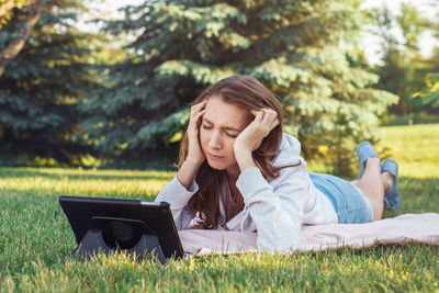 Young woman lying down on field