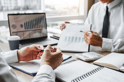 Midsection of business colleagues working at table