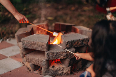 Midsection of man holding burning candles