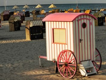 Hooded chairs on beach against buildings