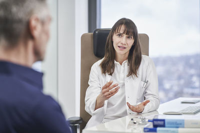 Female doctor talking to senior patient in medical practice