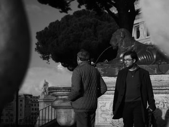 People standing by trees against plants