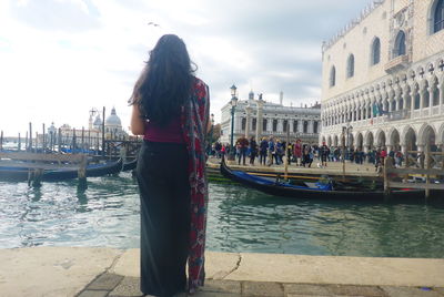 People standing on boats in canal