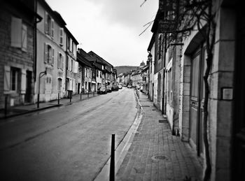 Empty road along buildings