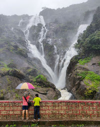 Scenic view of waterfall on mountain during rainy season