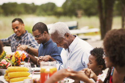 Happy family holding hands at breakfast table