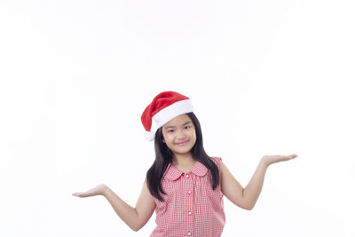 Portrait of smiling girl standing against white background