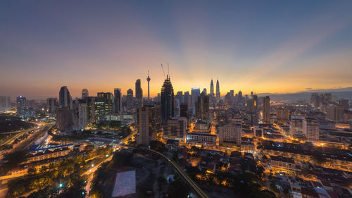 Aerial view of city lit up at sunset