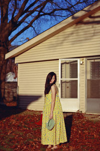 Full length of woman standing against brick wall