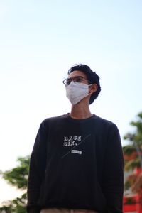 Portrait of young man standing against sky