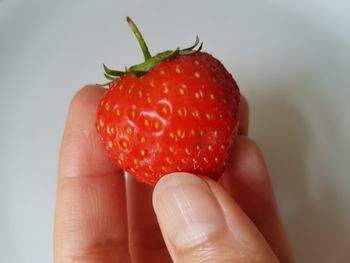 Close-up of hand holding strawberry