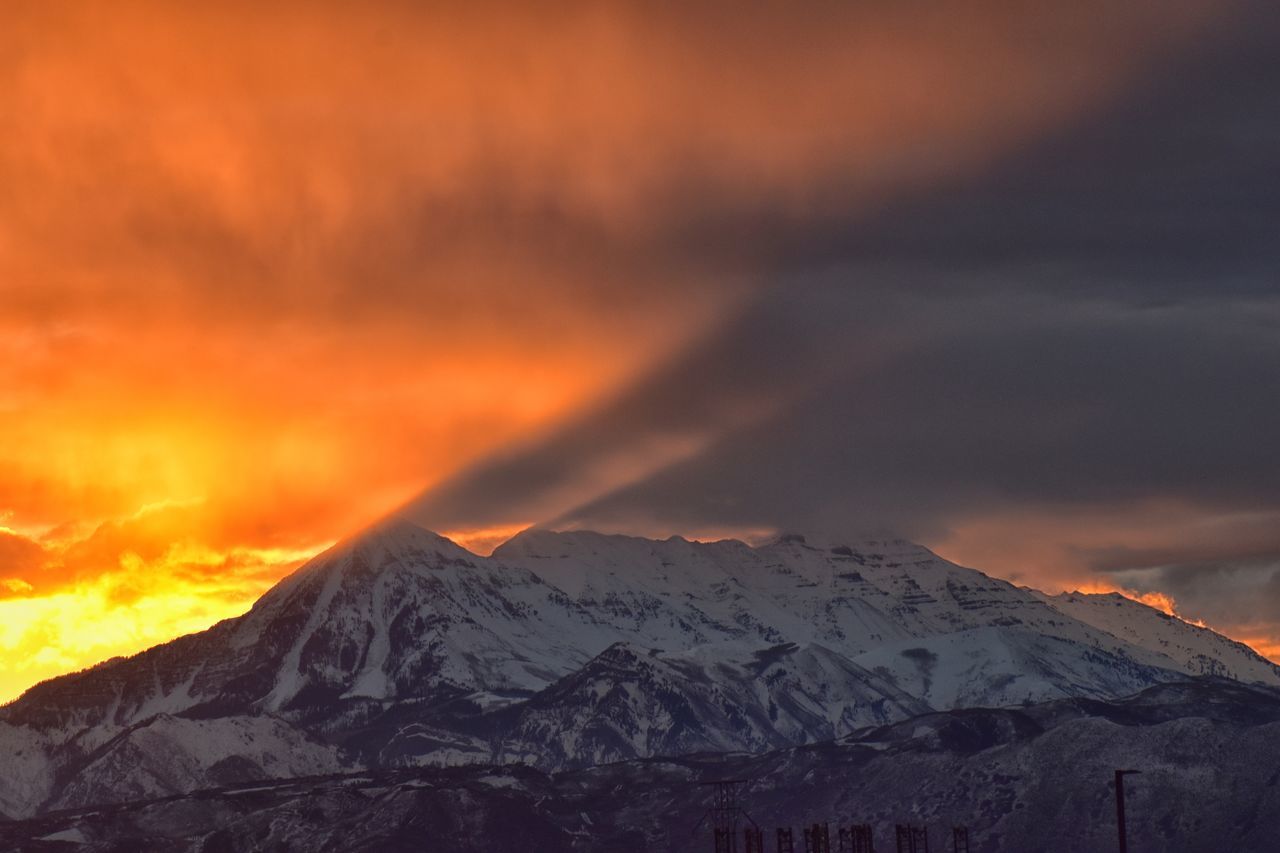 SCENIC VIEW OF SNOWCAPPED MOUNTAIN AGAINST ORANGE SKY