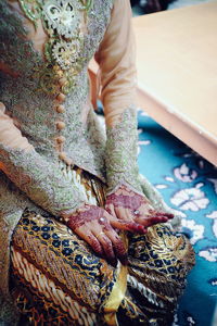 Midsection of bride kneeling on floor at wedding ceremony