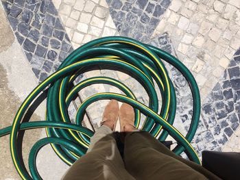 Low section of woman standing amidst water pipe