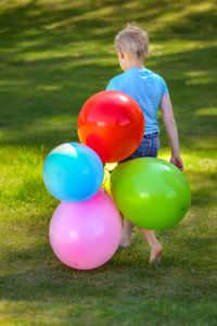 Boy with balloons on field