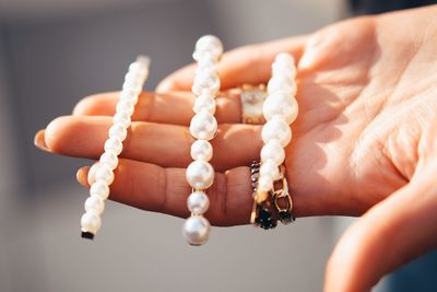 Cropped hand of woman holding jewelry