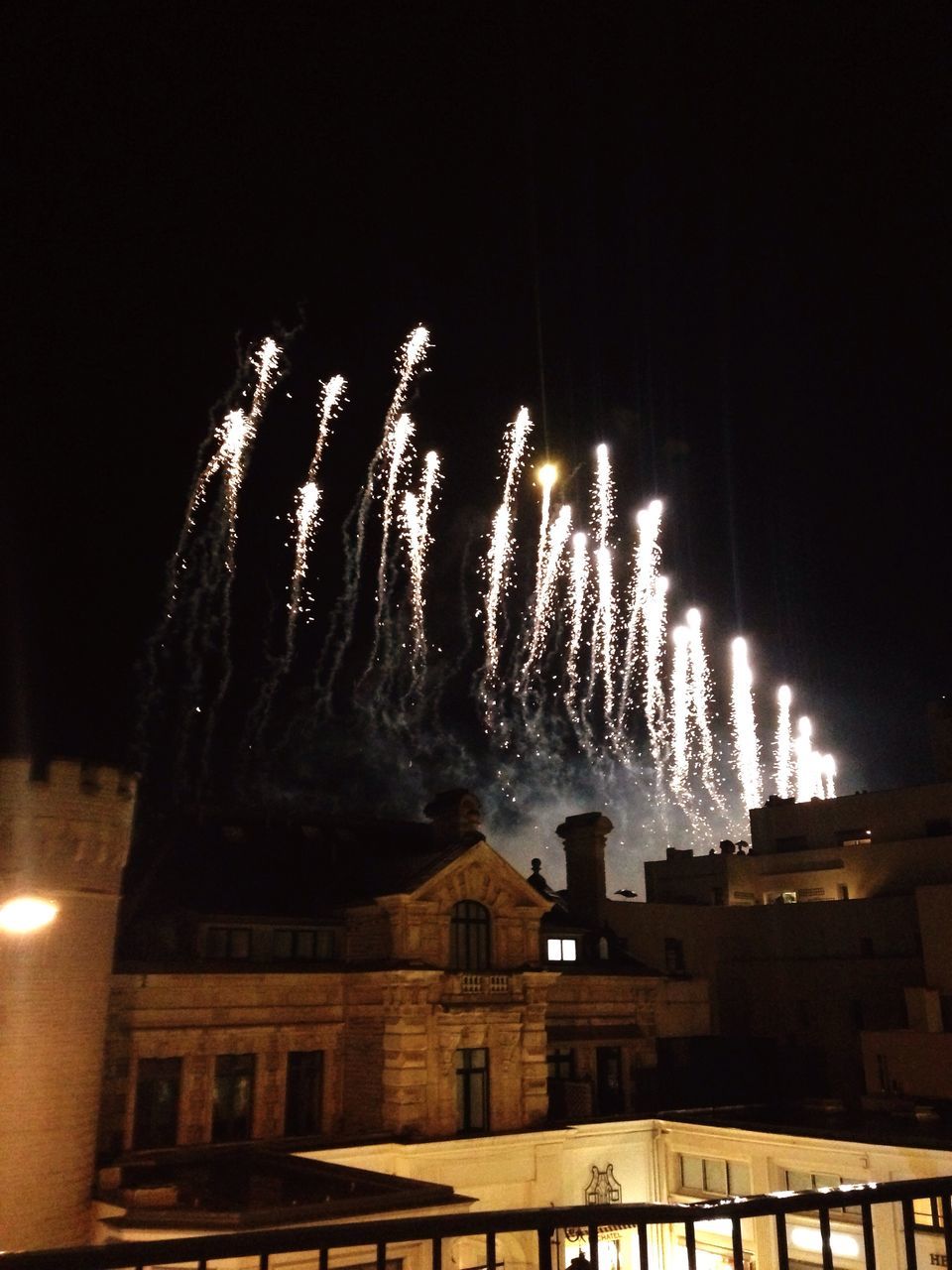 building exterior, architecture, built structure, night, illuminated, celebration, low angle view, firework display, long exposure, motion, house, exploding, sky, city, firework - man made object, sparks, outdoors, event, residential district