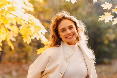 Portrait of young woman standing against plants