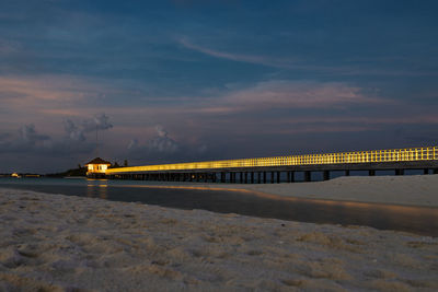 Pier over sea against sky at sunset