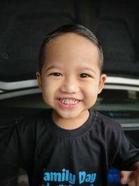 Portrait of smiling cute boy standing at home