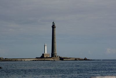 Lighthouse by sea against sky